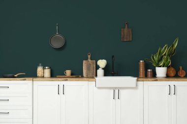 Beyaz tezgahlı, çatal bıçaklı ve lavabolu modern mutfak.