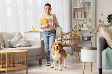 Little African-American boy with school backpack and cute beagle dog at home