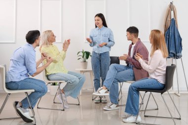 Young Asian woman talking at group therapy session