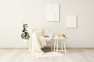 Beyaz koltuklu, masalı ve resimli bir oturma odası.