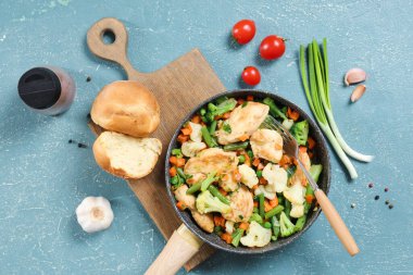 Renkli arkaplanda kızarmış tavuk fileto, sebze ve çörek kompozisyonu