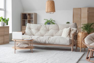 Masada yumuşak kanepe ve dizüstü bilgisayarla oturma odasının içinde.