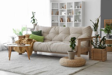 Interior of living room with soft couch and green plants
