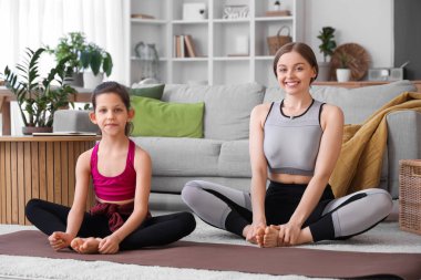 Little girl doing gymnastics with trainer at home