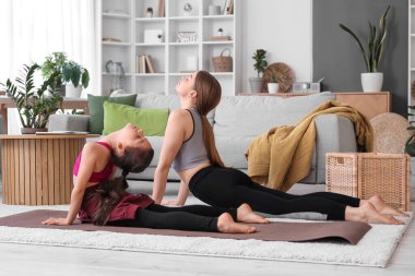 Little girl doing gymnastics with trainer at home