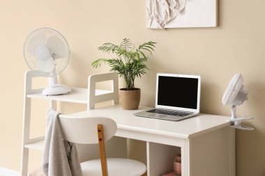 Elektronik vantilatörlü ve dizüstü bilgisayarlı modern işyeri