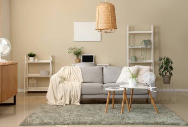 Interior of stylish living room with electric fans and decor
