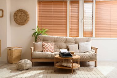 Interior of living room with vintage typewriter on table and sofa