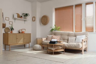 Interior of living room with sofa, drawers and vintage typewriter on table