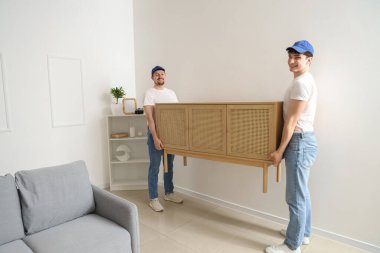 Loaders carrying commode in room