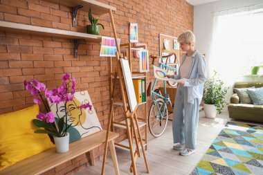 Ofiste renk paletleri ile çalışan kadın grafik tasarımcısı