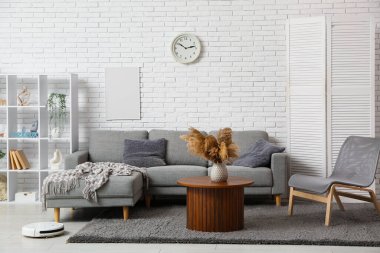Interior of modern living room with robot vacuum cleaner on floor
