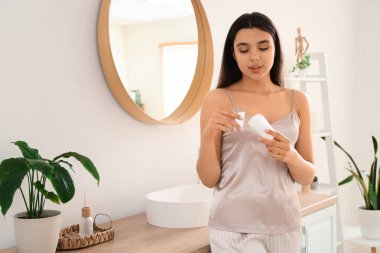 Banyoda deodorantı olan genç bir kadın.