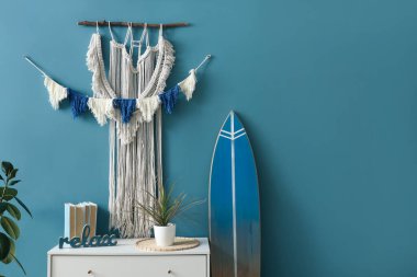 Mavi duvarda asılı duvar halısı