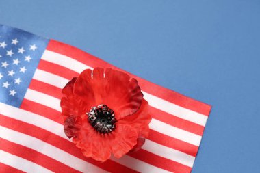 Flag of USA and poppy flower on blue background, closeup. Memorial Day celebration