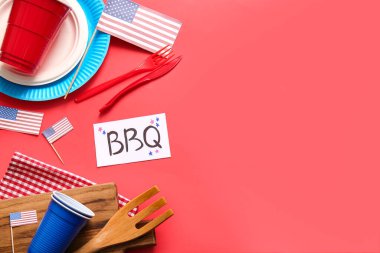 BBQ harfli kart, yemek takımı ve kırmızı arka planda Amerikan bayrakları. Bağımsızlık Günü kutlamaları
