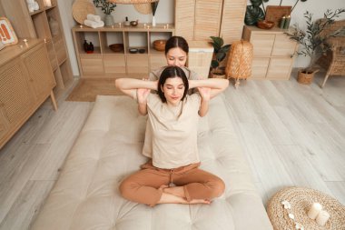 Young woman getting Thai massage from therapist in spa salon