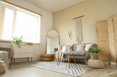 Interior of cozy living room with sofa, dream catcher and wall tapestry
