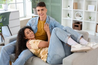 Happy young couple spending time together on sofa at home