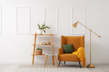 Brown armchair, coffee table and shelving unit near white wall