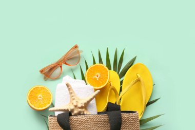 Renkli arka planda şık plaj aksesuarları, palmiye yaprağı ve portakalı kompozisyon