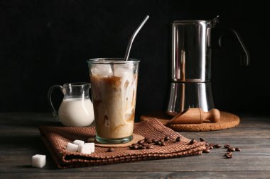 Kahve çekirdekli buzlu latte ve tahta masada küp şeker.