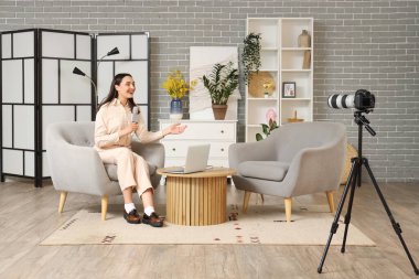Female reporter with microphone recording coverage in studio