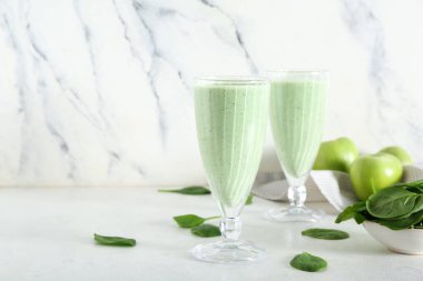Beyaz arka planda elmalı taze ıspanaklı smoothie.