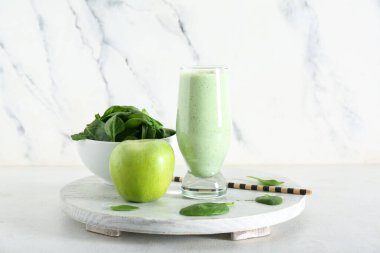 Beyaz arkaplanlı bir bardak taze ıspanaklı smoothie.