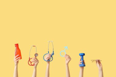 Female hands with stethoscopes, male sign, dumbbell and eyeglasses on yellow background. Prostate cancer concept