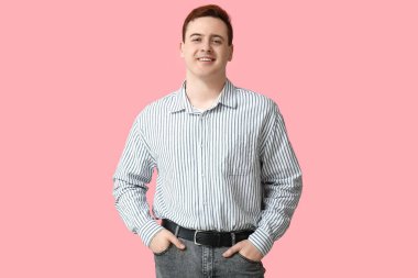 Handsome young man in stylish striped collar shirt on pink background