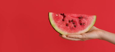 Kırmızı zemin üzerinde karpuz dilimi ve metin için yeri olan kadın eli