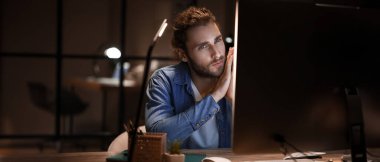 Geceleri ofiste çalışan yakışıklı bir adam. Tasarım için pankart