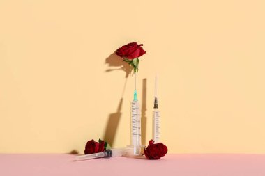 Renk arkaplanında çiçekler olan boş şırıngalar