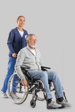 Tekerlekli sandalyedeki kıdemli adam ve parlak bir geçmişi olan hemşire.