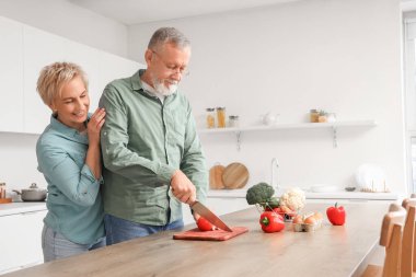 Mutfakta domates kesen olgun bir çift.