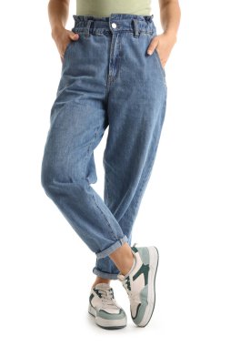 Beyaz arka planda modaya uygun kot giyen genç bir kadın.