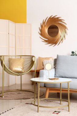Altın aynası, koltuğu ve koltuğu olan aydınlık oturma odasının içi.