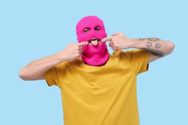 Mavi arka planda poz veren kar maskeli yakışıklı genç adam.