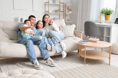 Evde kanepede televizyon izlerken aile