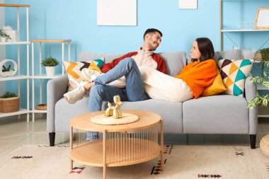 Güzel genç mutlu çift evdeki kanepede dinleniyor.