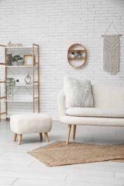 İçinde kanepe, puf ve raf ünitesi olan modern ışık oturma odası.