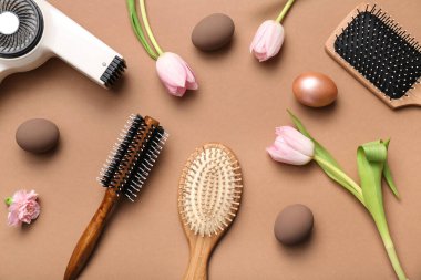 Kuaför aksesuarları, laleler ve açık kahverengi arka planda Paskalya yumurtaları.