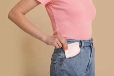 Bej arka planda regl pedi cebine koyan kadın