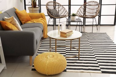 Masasında kanepe, koltuk ve çerçeveler olan şık bir oturma odası.