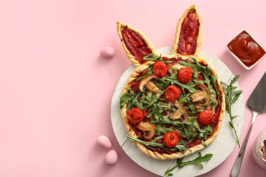 Lezzetli pizzalı kompozisyon ve pembe arka planda Paskalya yumurtası.