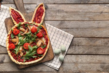 Tahta arka planda lezzetli pizza ve yumurtalı pano. Paskalya kutlaması