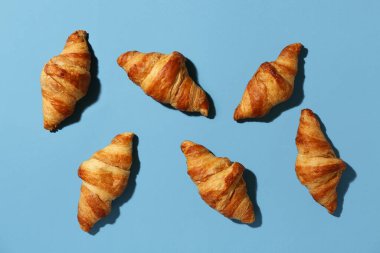 Mavi arka planda bir sürü lezzetli kruvasan