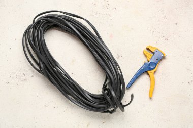 Beyaz grunge arka planında siyah kablo ve tel sökücü