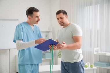 Genç adam klinikte beslenme uzmanını ziyaret ediyor.